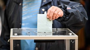 Ein Wähler wirft seinen Wahlzettel in eine Box.