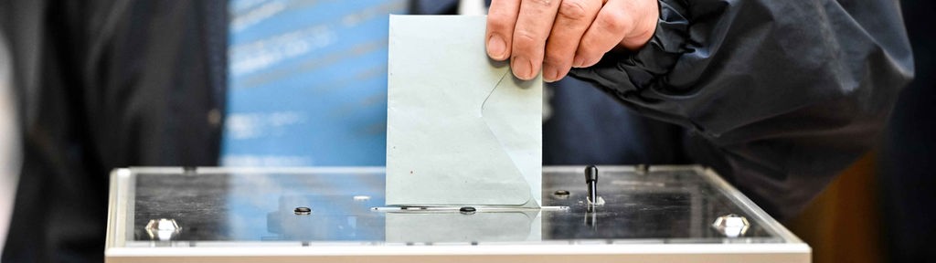 Ein Wähler wirft seinen Wahlzettel in eine Box.