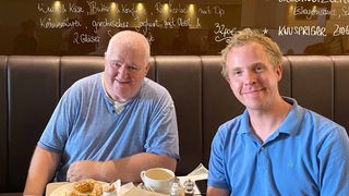 Markus Maria Profitlich und Daniel Schlipf beim Frühstück in einem Café