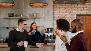 Kollegen beim Pizzakaffee in der Pause einer Bürobesprechung