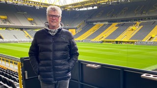Norbert Dickel steht vor den leeren Rängen des Stadions der Borussia aus Dormtund.