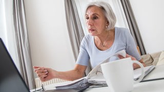 Rentnerin arbeitet gestresst am Computer