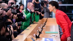 Zahlreiche Kameraobjektive richten sich auf Sahra Wagenknecht, als sie an einem Rednerpult der Bundespressekonferenz Platz nimmt