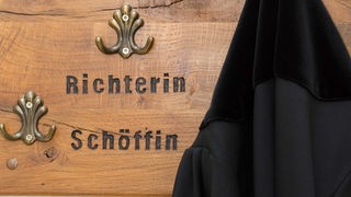 Ein Richter hängt seine Robe am im Landgericht Osnabrück (Niedersachsen) an eine Garderobe für Richter und Schöffen. 