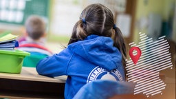 Schülerinnen und Schüler einer Grundschule sitzen in ihrem Klassenraum.