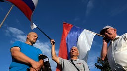 Bosnische Serben, die russische Nationalflaggen schwenken, versammeln sich in den Außenbezirken der Hauptstadt Sarajevo, nachdem die Staatsanwaltschaft den bosnisch-serbischen politischen Führer Milorad Dodik angeklagt hat.