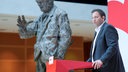 SPD-Vorsitzender Lars Klingbeil SPD steht an einem Rednerpult – im Hintergrund ist eine Statue von Willy Brandt zu sehen.