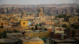 Blick über teils verfallene Häuser im ärmlichen Viertel und Friedhof "Stadt der Toten" in Kairo.