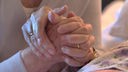 Symbolbild zum Thema Sterbehilfe: zwei Hände mit Eheringen ineinander verschlungen