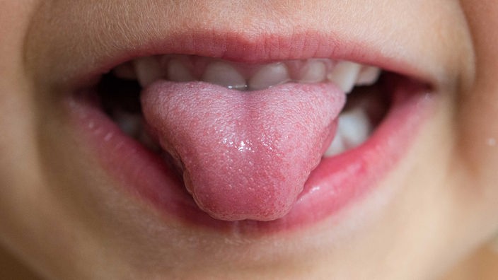 Ein fünfjähriges Mädchen steckt die Zunge aus dem Mund