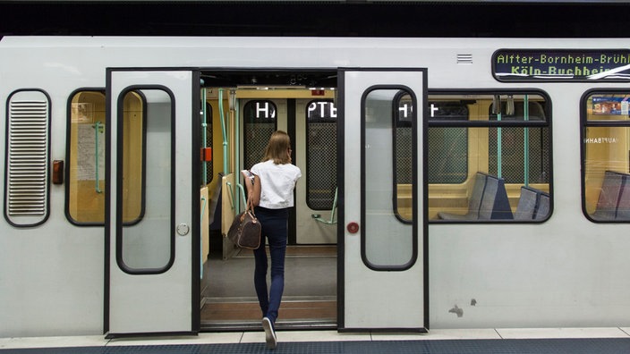 Frau steigt in eine Straßenbahn