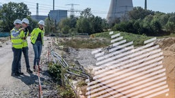 Menschen mit Bauhelmen stehen am Rande der Südostlink-Trasse