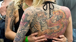 Ein Tiger und ein Drache sind am 21.03.2015 auf der "International Tattoo-Convention" in Frankfurt am Main (Hessen) auf dem Rücken einer Frau zu sehen.