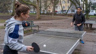 Junges Paar spielt im Park Tischtennis