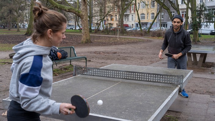 Junges Paar spielt im Park Tischtennis