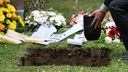 Ein Tobiasbruder lässt bei einer Gemeinschaftsbestattung der Tobiasbruderschaft eine Urne in ein Grab ein. Die Tobiasbruderschaft Göttingen bestattet Menschen ohne familiäre Angehörige.