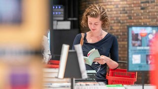 Eine Frau stöbert in einem Buchgeschäft in Utrecht. Die niederländische Stadt ist Unesco Literaturstadt