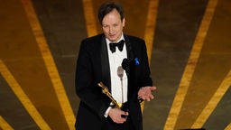 Volker Bertelmann nimmt den Oscar für die beste Filmmusik für "Im Westen nichts Neues" an.