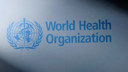 Das Logo der Weltgesundheitsorganisation zwischen Licht und Schatten.
