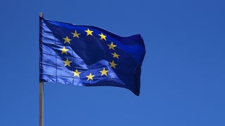Eine gehisste Europa Flagge vor blauem Himmel