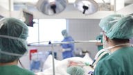 Operationssaal, zwei Krankenpflegerinnen beobachten eine Operation