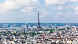 Aussicht auf die Stadt von der Kuppel der Basilika Sacré Coeur (Sacre Couer) aus. Der Himmel ist wolkenlos und blau. Zu sehen sind die Dächer von Paris sowie der Eiffelturm.