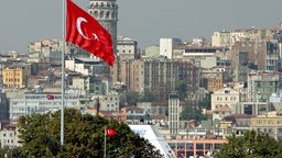Blick auf Istanbul mit dem Galata-Turm, der halb verdeckt ist durch eine türkische Flagge