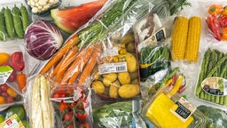 Gemüse und Obst einzeln in Plastikfolie verpackt