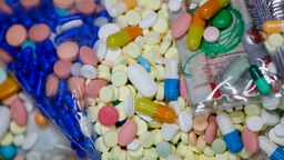 Zu sehen sind lauter Tabletten in verschiedenen Formen und Farben, die alle auf einem Haufen liegen