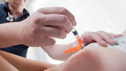 Ein Kind wird von einem Artzt gegen Masern geimpft