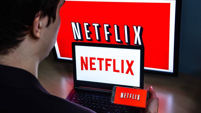 Das Netflix Logo auf einem TV, Laptop und Handy