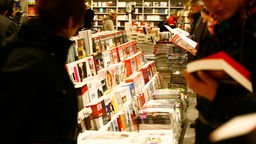 Kunden lesen in Zeitschriften und Büchern in einer Bahnhofs-Buchhandlung (Symbolbild).