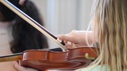 Ein Mädchen spielt auf einer Geige.