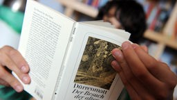 Ein Schüler liest in Dürrenmatts tragischer Komödie "Der Besuch der alten Dame"