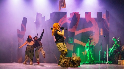 Yulia Yáñez Schmidt, Annina Hunziker, Sophie Stockinger und die Band(e) in einer Szene aus "Robin Hood"