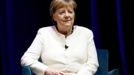 Angela Merkel sitzt in einem Sessel und hört zu bei der Vorstellung ihres Buches Freiheit