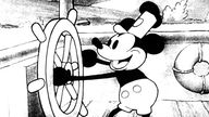Gezeichnete Micky Maus steht in erster Animation 1928 "Steamboat Willie" an einem Schiffssteuerrad.