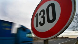 An einer Autobahn steht ein Schild, das die erlaubte Höchstgeschwindigkeit mit 130 km/h anzeigt.