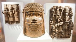  Drei Raubkunst-Bronzen aus dem Land Benin in Westafrika sind im Museum für Kunst und Gewerbe (MKG) in einer Vitrine ausgestellt.
