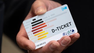  Eine Hand hält ein "D-Ticket" im Chipkartenform