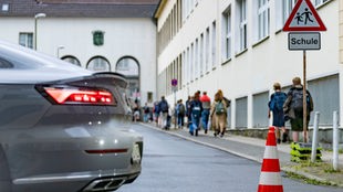 Pylonen stehen auf der Straße vor einer Schule, um sie für Autos abzusperren