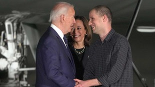  US-Präsident Joe Biden (l-r) und Vizepräsidentin Kamala Harris begrüßen den Reporter Evan Gershkovich auf der Andrews Air Force Base nach seiner Freilassung im Rahmen eines Gefangenenaustauschs. 