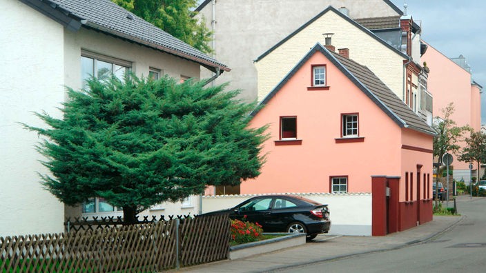 Symbolbild zur Grundsteuererklärung: Ein Straße mit einem Einfamilienhaus und Mehrfamilienhäuser.