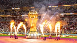 Ein großers WM-Pokal von Feuer umgeben bei der Eröffnungsfeier der Fußball-Weltmeisterschaft am 20.11.2022 in Katar.