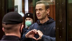 Oppositionsführer Alexej Nawalny, der im Gerichtssaal mit seinen Händen ein Herz formt.