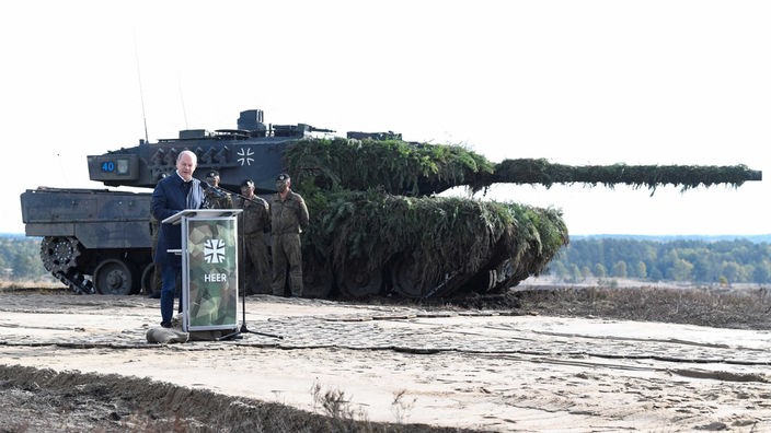 Scholz besucht die Militärbasis in Bergen, im Hintergrund ein Leopard-Panzer