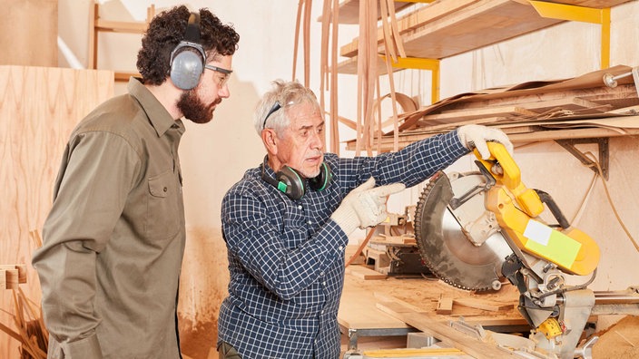 Symbolbild Rente: Schreiner Meister und Azubi an der Kappsäge.