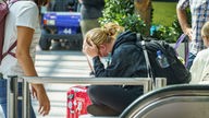 Eine Reisende wartet im Terminal 2 des Frankfurter Flughafens. Nach Beginn der Sommerferien in Hessen, Rheinland-Pfalz und dem Saarland kam es zu einem starken Andrang von Passagieren.