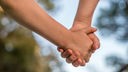 Symbobild Zusammenhalt und Zuversicht: Zwei Hände, die sich halten. Laut einer Studie sind viele junge Menschen unzufrieden mit ihrer psychischen Gesundheit. 