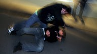 Symbolbild: Ein Jugendlicher schlägt auf ein am Boden liegendes Opfer ein